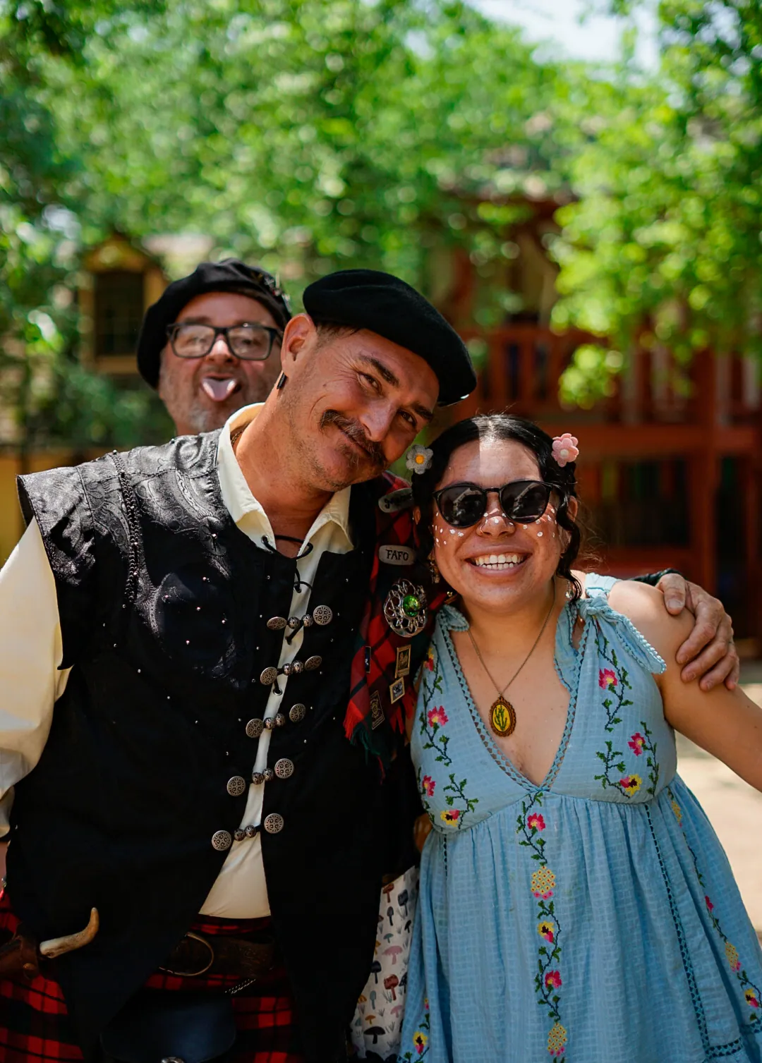 Two festival-goers in Renaissance fair costume smiling at the camera
