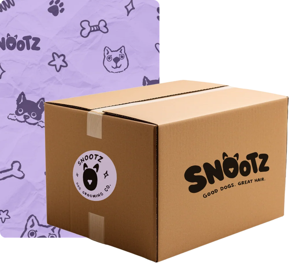 SNOOTZ packaging: a cardboard shipping box with the SNOOTZ logo and a round sticker, in front of lilac tissue paper printed with dog illustrations
